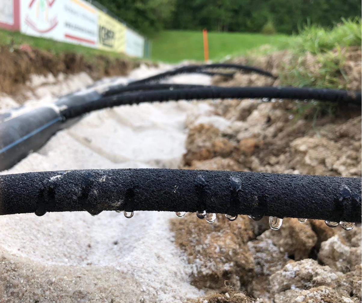 Bewässerungsschlauch der IRRIGATECS® Subsurface-Bewässerung gibt Wasser über seine gesamte Länge in Tropfen ab
